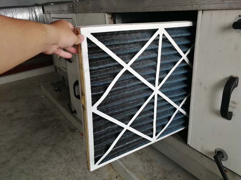 A dirty air filter being changed out by an HVAC technician