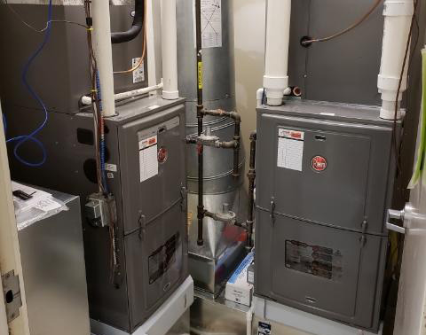 Rheem Indoor Furnaces standing next to one another in a small room